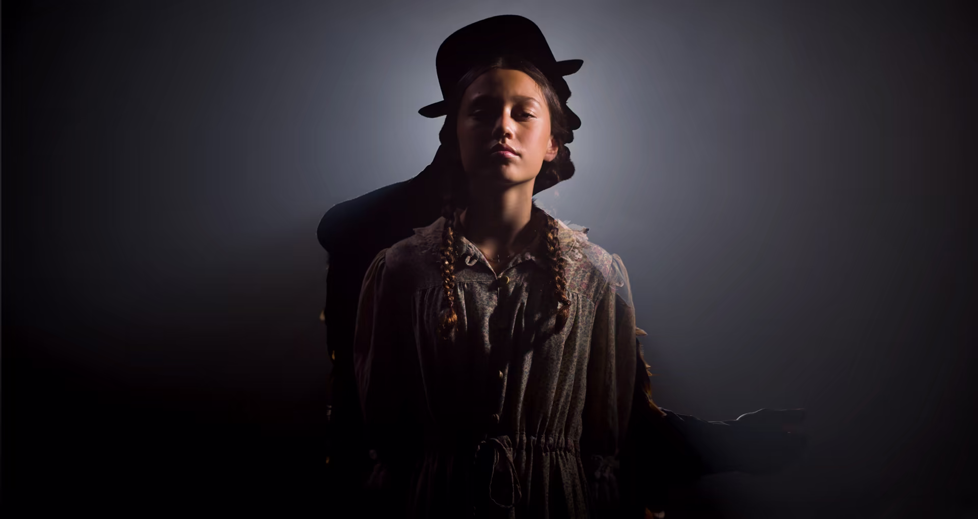 Poster still from The Way of the Raukura, a young performer backlit in a top hat